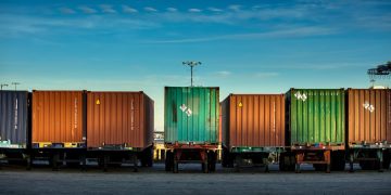 alignement de camions porte-container sous un ciel bleu