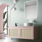 un meuble rose aux portes en rotin