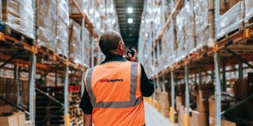 homme en gilet orange dans un bâtiment de stockage