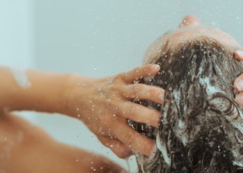 Femme se lavant les cheveux sous la douche