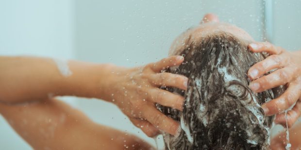 Femme se lavant les cheveux sous la douche