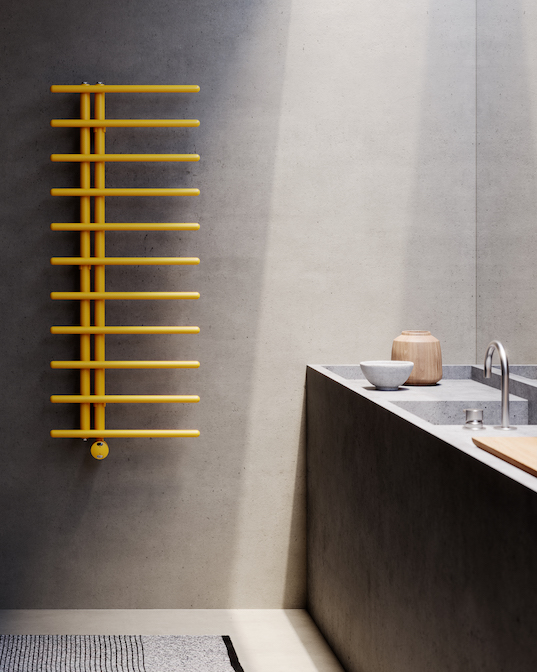 Sèche-serviettes jaune Pavone de Caleido dans une salle de bains aux murs façon béton