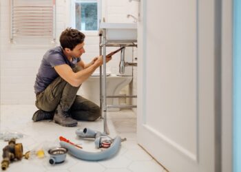 Jeune homme installant une bonde de lavabo