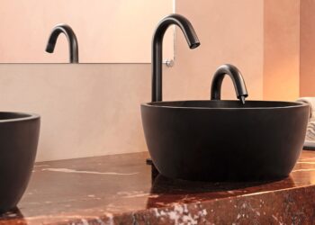 Sur un plan de toilette en marbre rouge, vasque bol noire et robinet noir électronique Eléos de Pellet ACS