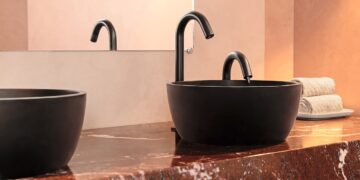 Sur un plan de toilette en marbre rouge, vasque bol noire et robinet noir électronique Eléos de Pellet ACS