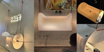 Un lavabo cylindrique, suspendu à l'aide de cordes, dont la matière translucide laisse passer la lumière